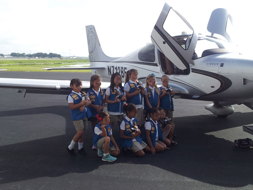 Image of Girl Scouts group infront of Cirrus airplane