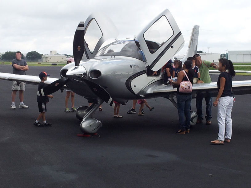 Image of group looking at Cirrus airplane