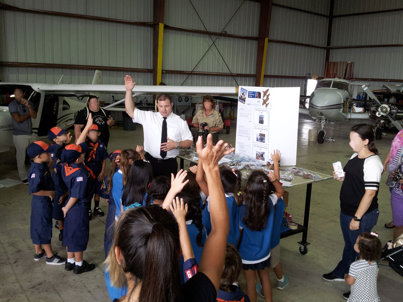 Image of Boy Scouts and Girl Scouts raising their hands in the air