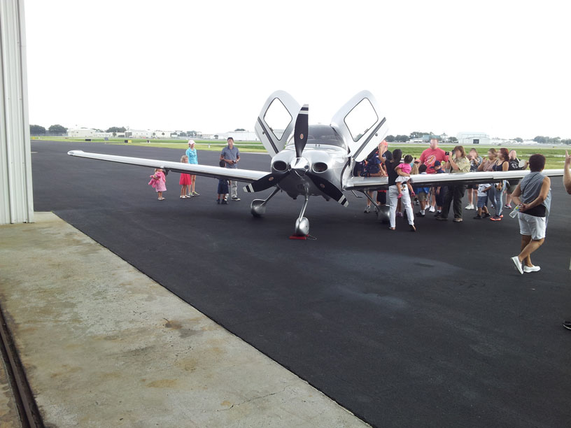 Image of group looking at Cirrus airplane