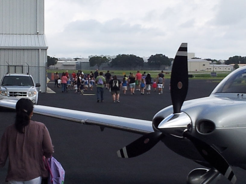 Image of group looking at airplane